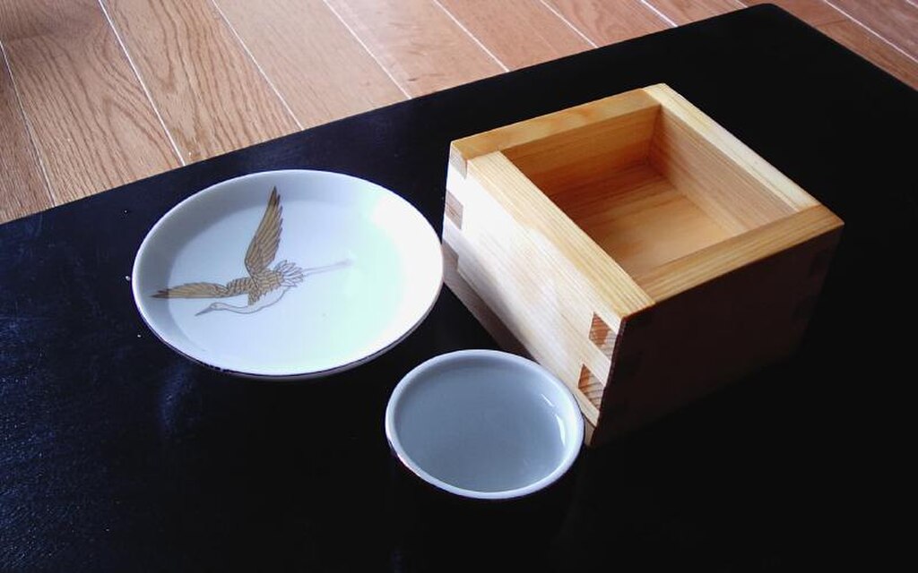 A traditional Japanese sake set with sakazuki, ochoko, and masu vessels