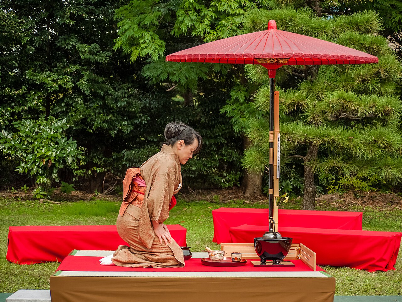 A Japanese tea ceremony in progress, with a host preparing matcha