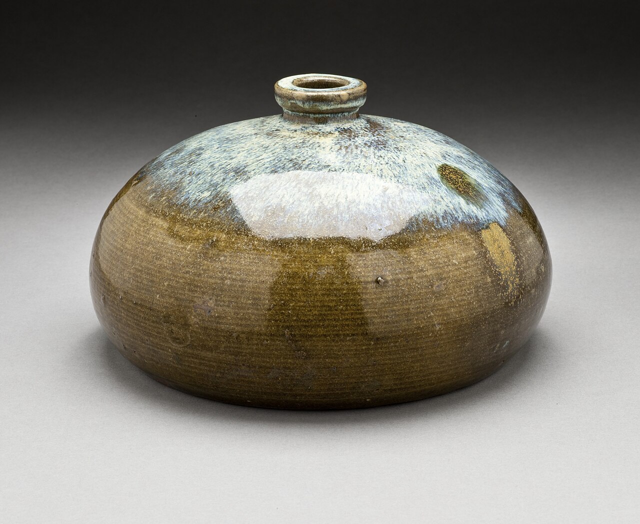 Shodai-yaki vessel showing poured uchikake glaze streaming over a dark body