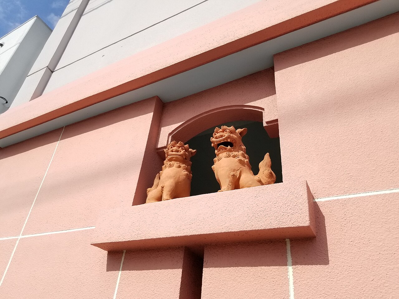 A pair of ceramic shisa guardian lions mounted on an Okinawan building in Naha