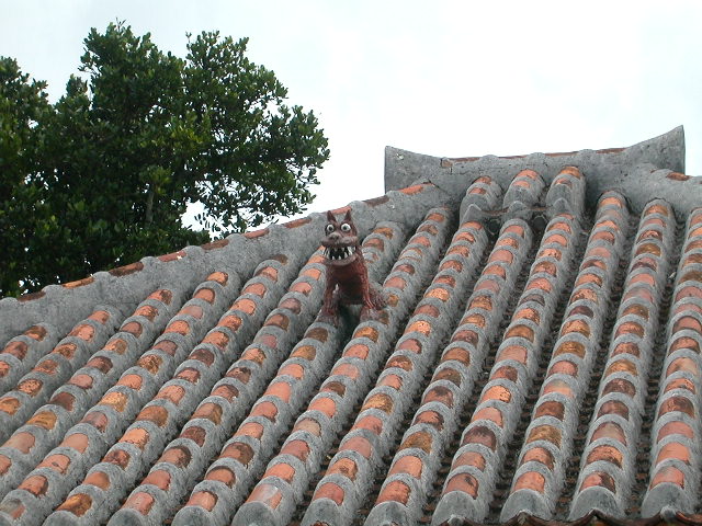 A ceramic shisa standing guard on an Okinawan rooftop