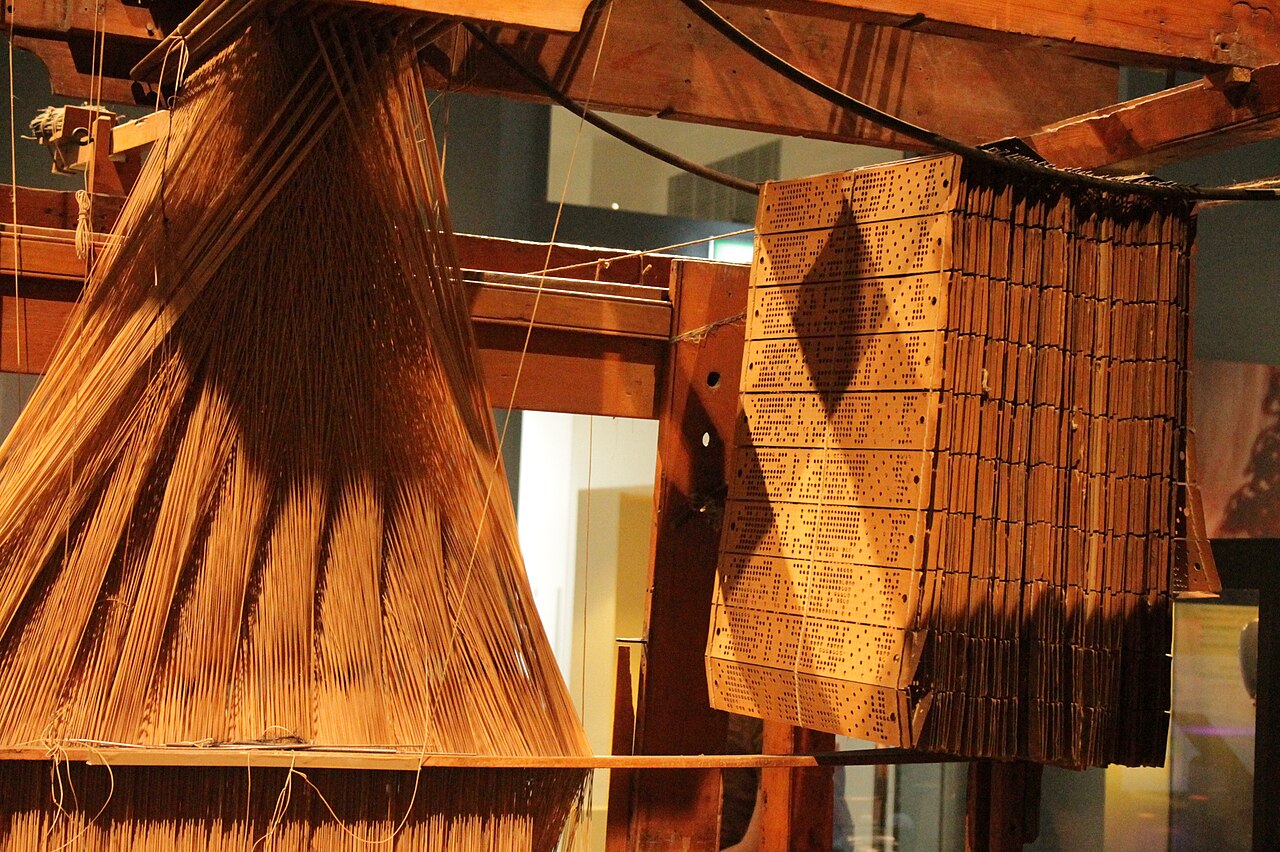 Jacquard loom with punch-card mechanism controlling individual warp threads